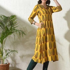 Woman posing in stylish Ajrakh printed kurta, showcasing ethnic fashion indoors.
